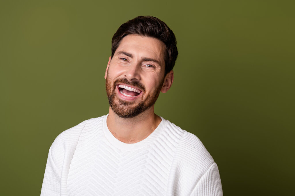 Portrait of a man smiling toothily.