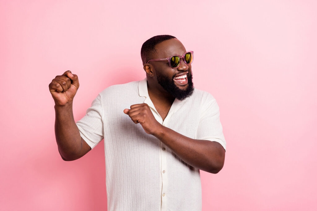 Man smiling and happy with a pink background.