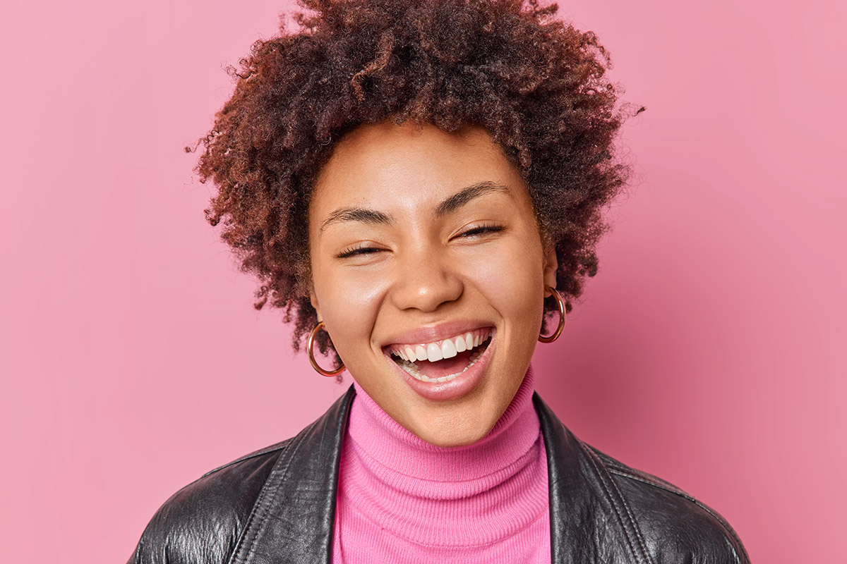 A close-up of a beautiful young woman's smile with Emprethin Veneers.