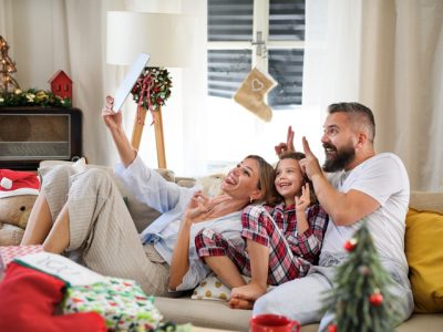 A family taking a selfie together at Christmas while lounging on the couch.