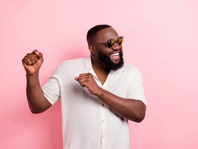 Man smiling and happy with a pink background.