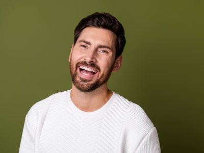 Portrait of a man smiling toothily.