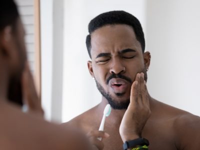 Stressed upset mixed raced Black man feeling pain and discomfort
