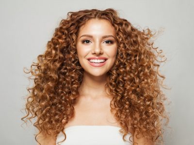 A smiling woman with curly hair.